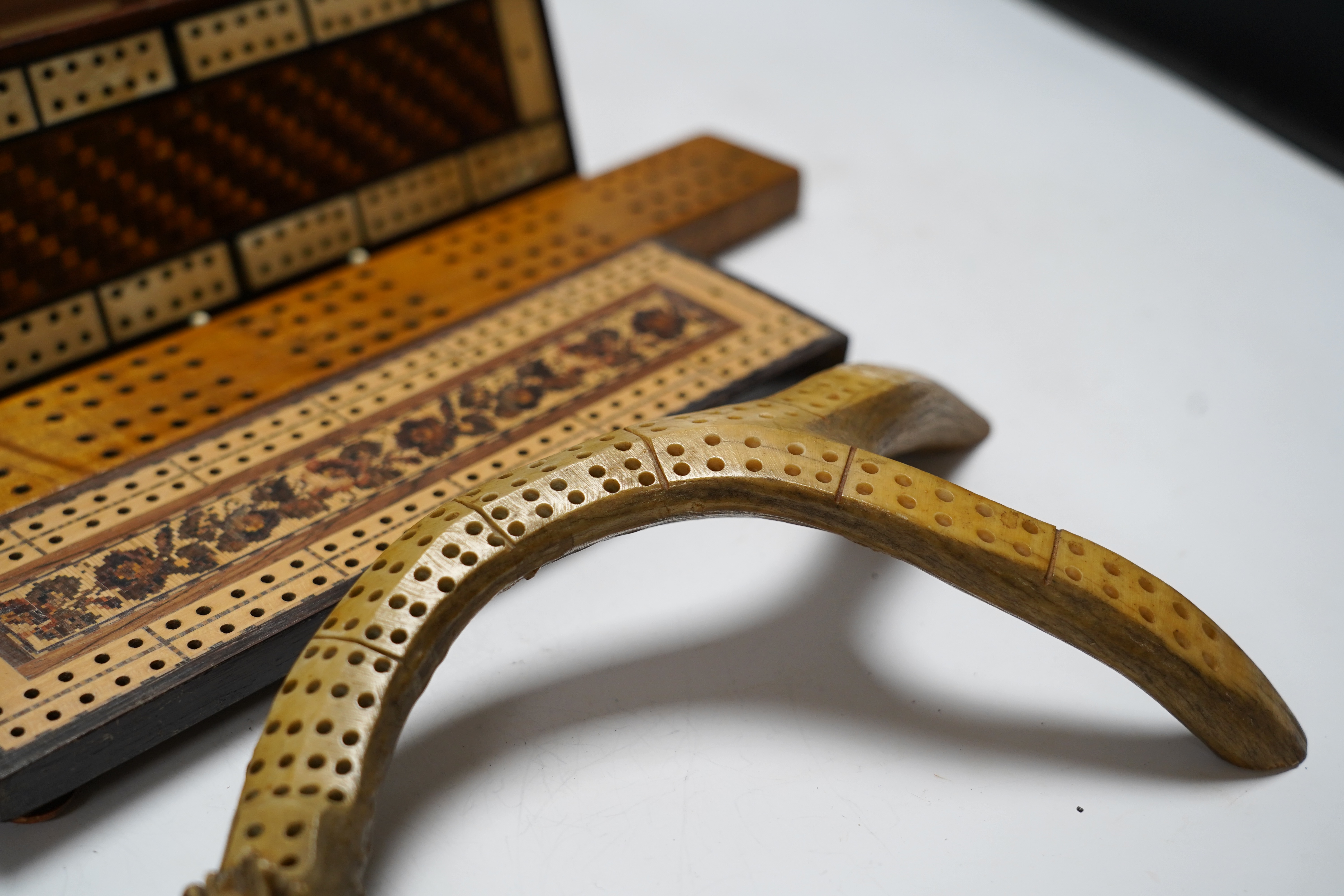 Nine cribbage boards including a horn example, 'Wills Tobacco' advertising and bone and marquetry examples, largest 42cm in length